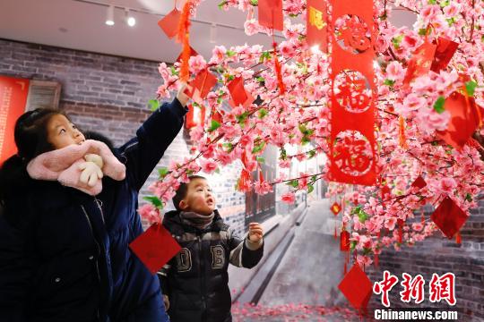 孩子們?cè)谠S愿樹(shù)下寫下新年祝福。 殷立勤 攝