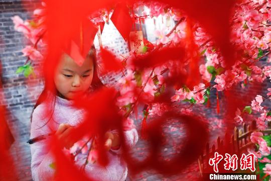 孩子在許愿樹(shù)下寫下新年祝福。 殷立勤 攝